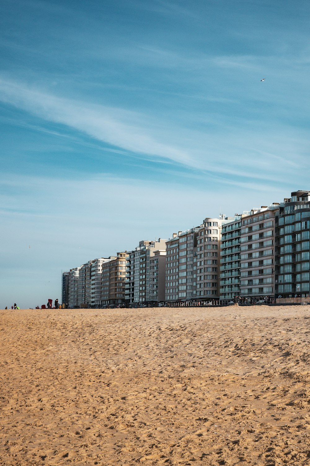 a row of apartment buildings sitting on top of a sandy beach