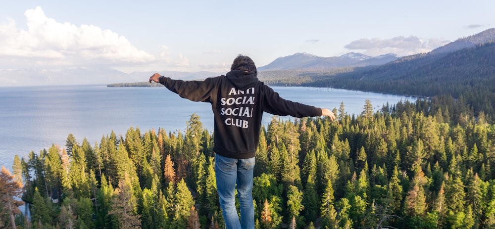 a man standing on top of a mountain with his arms outstretched