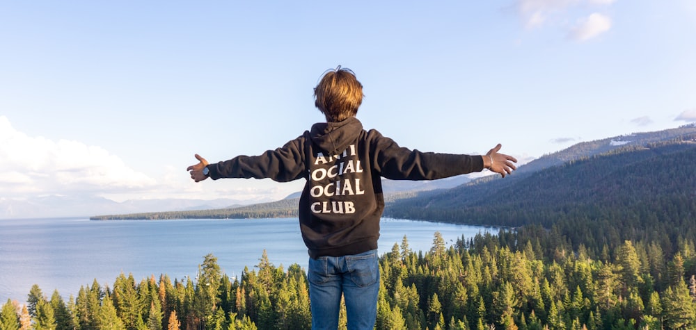 a man standing on top of a mountain with his arms outstretched