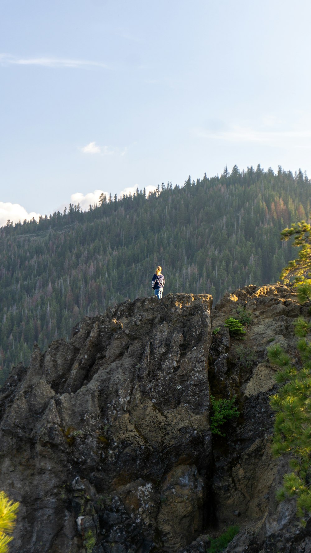 two people sitting on top of a large rock