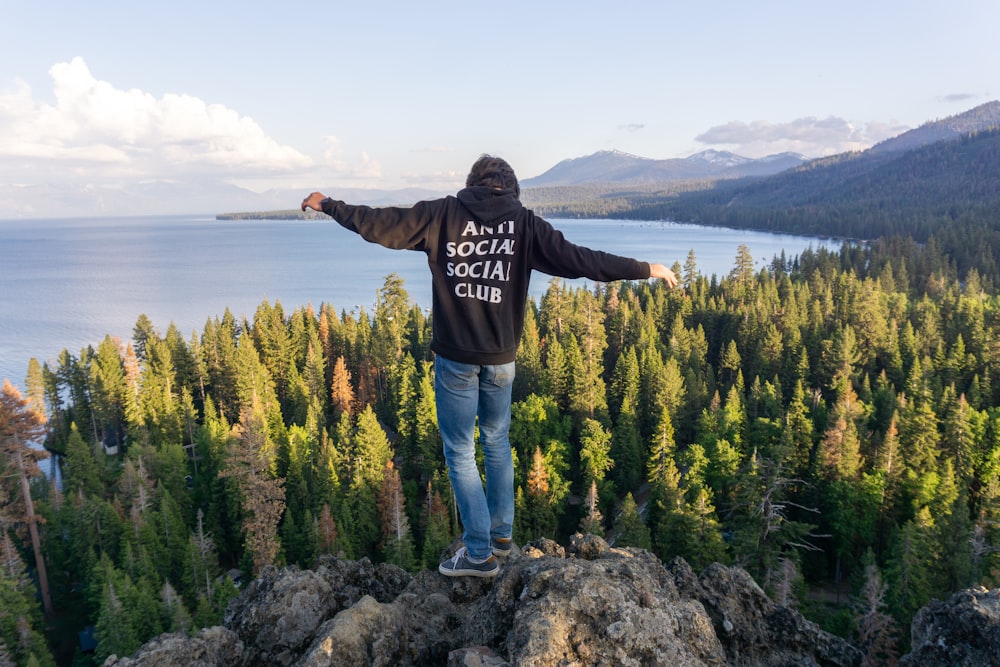 a man standing on top of a mountain with his arms outstretched