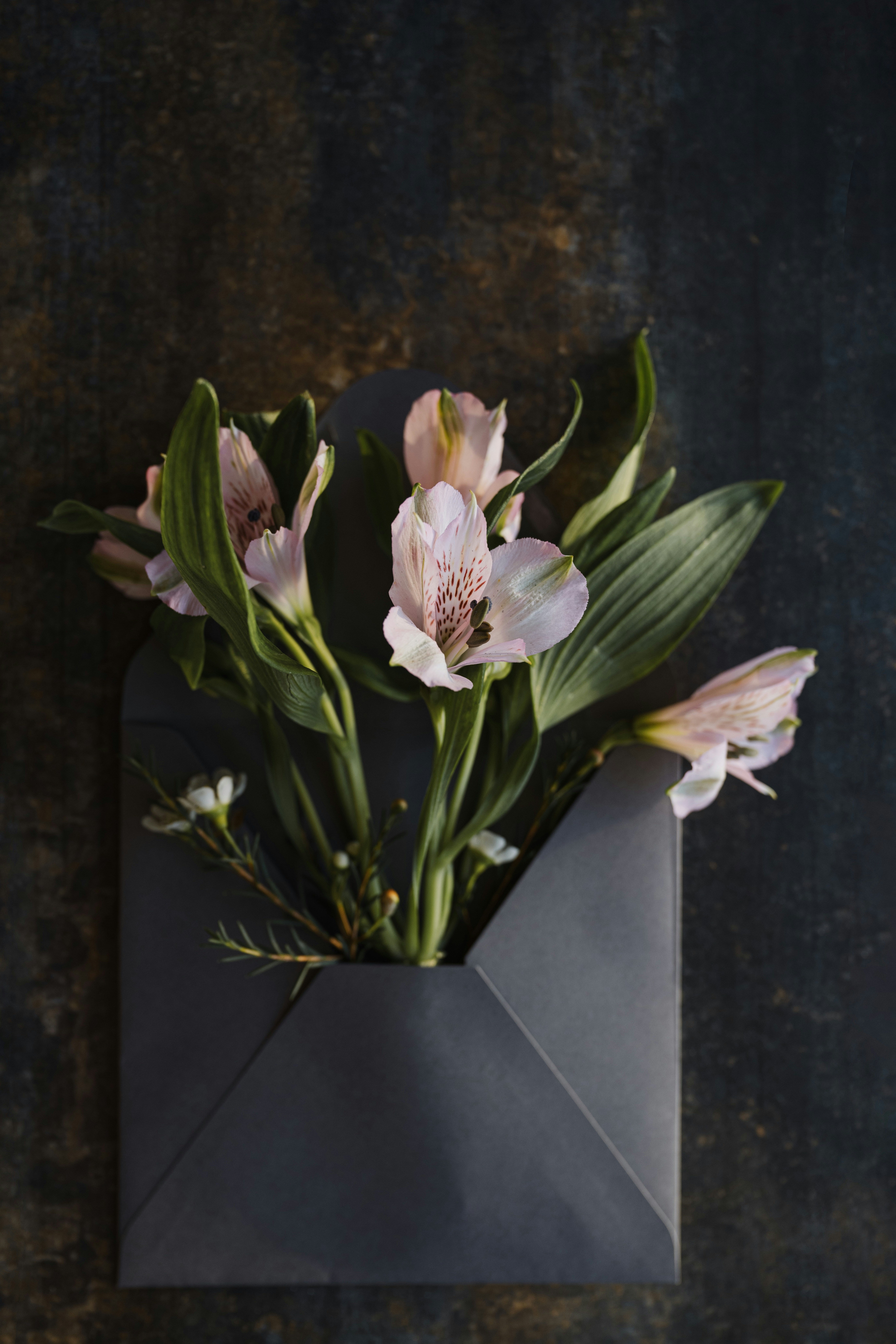 a bouquet of flowers in an envelope on a table