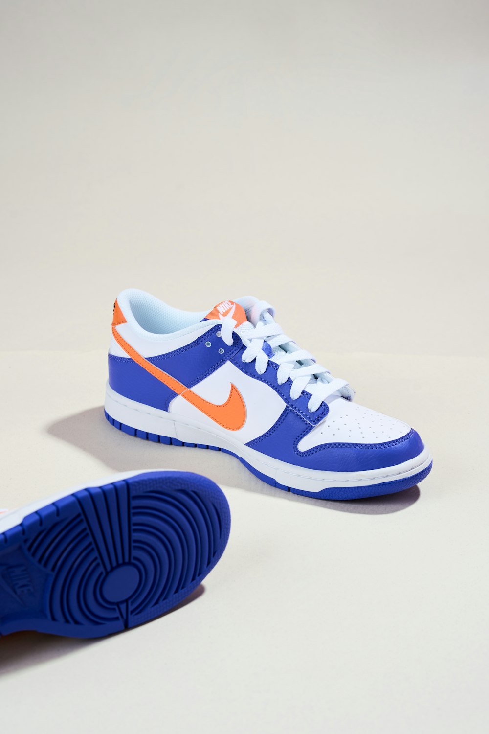 un par de zapatillas azules y naranjas sobre una superficie blanca