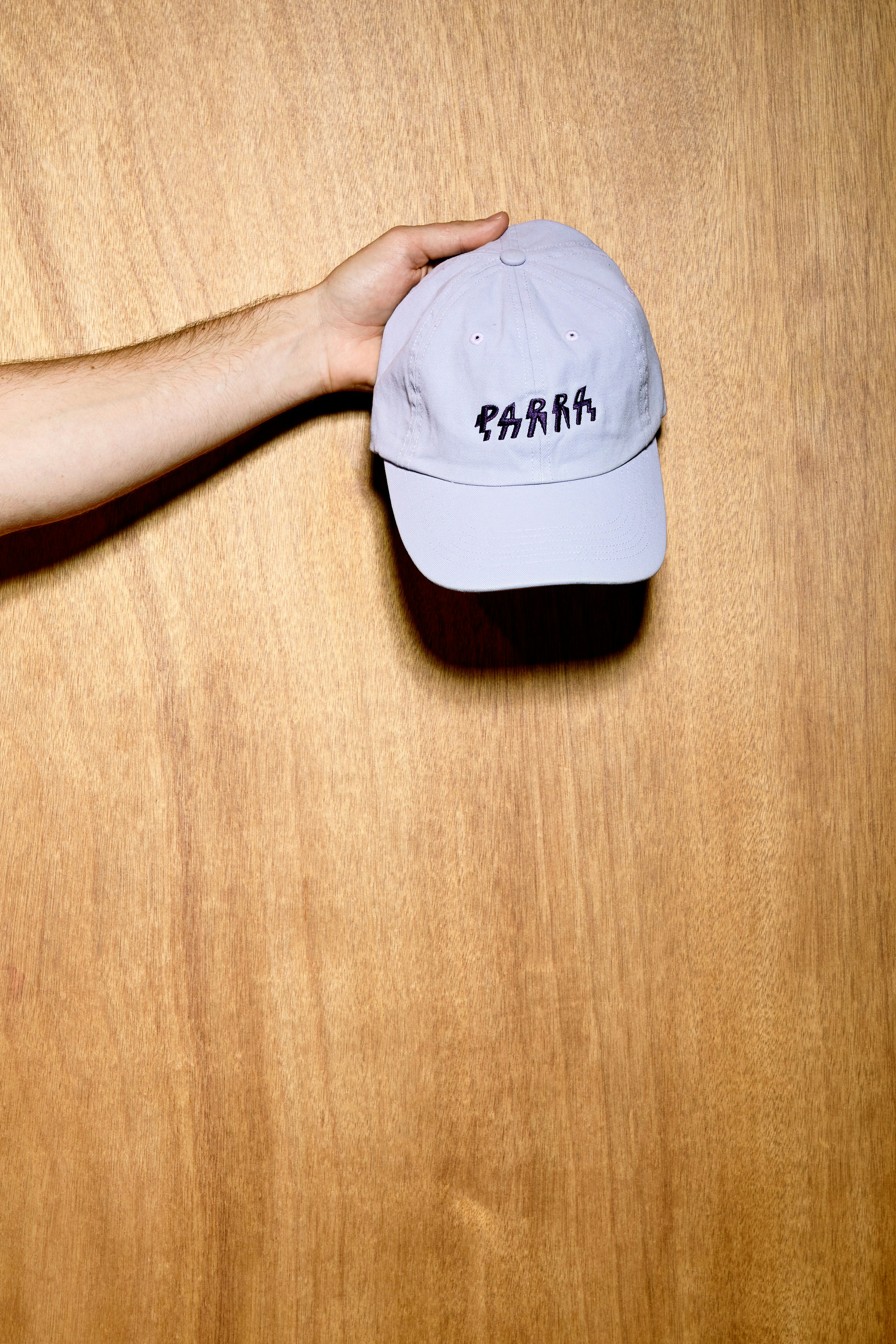 a person holding a hat on top of a wooden table