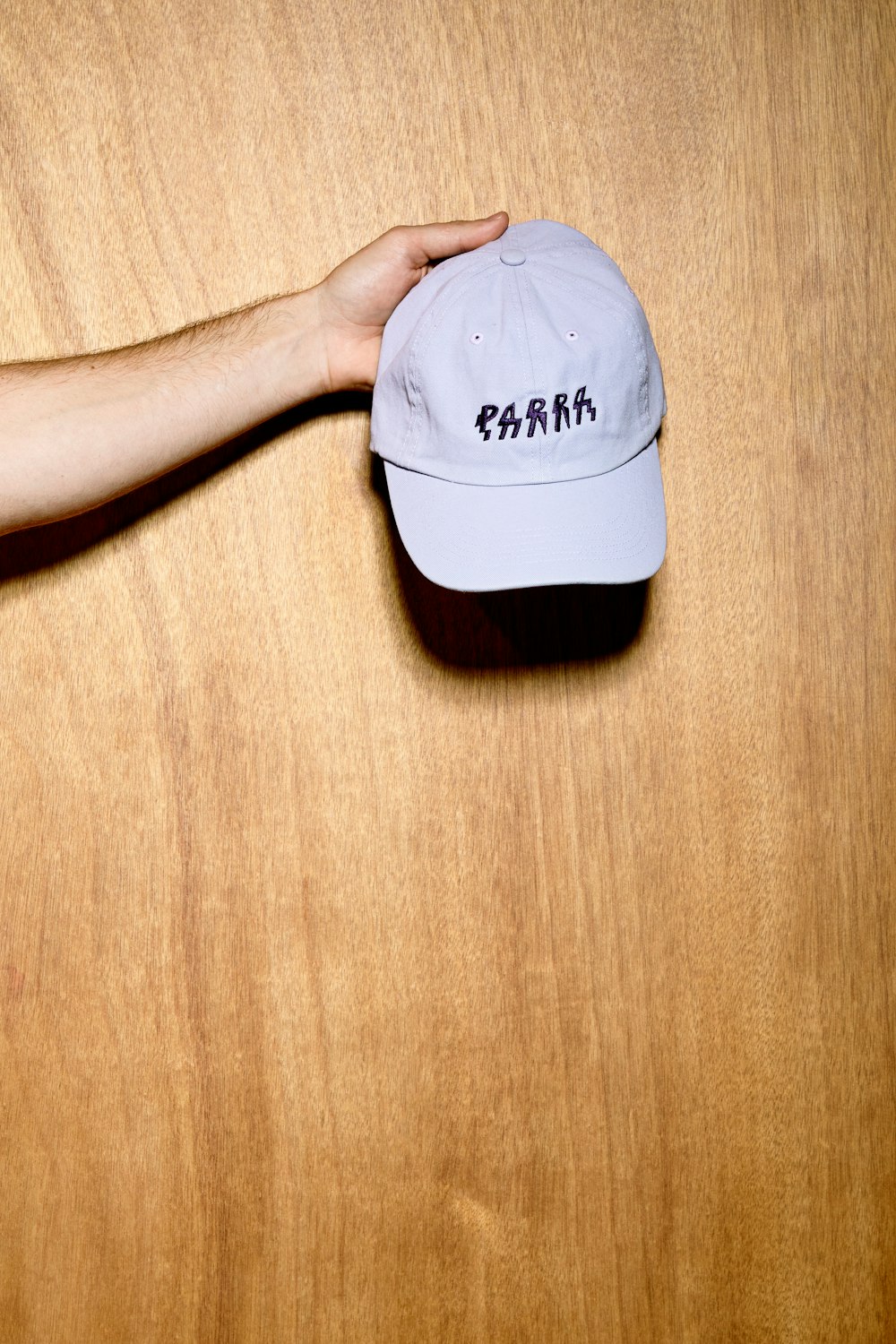 a person holding a hat on top of a wooden table