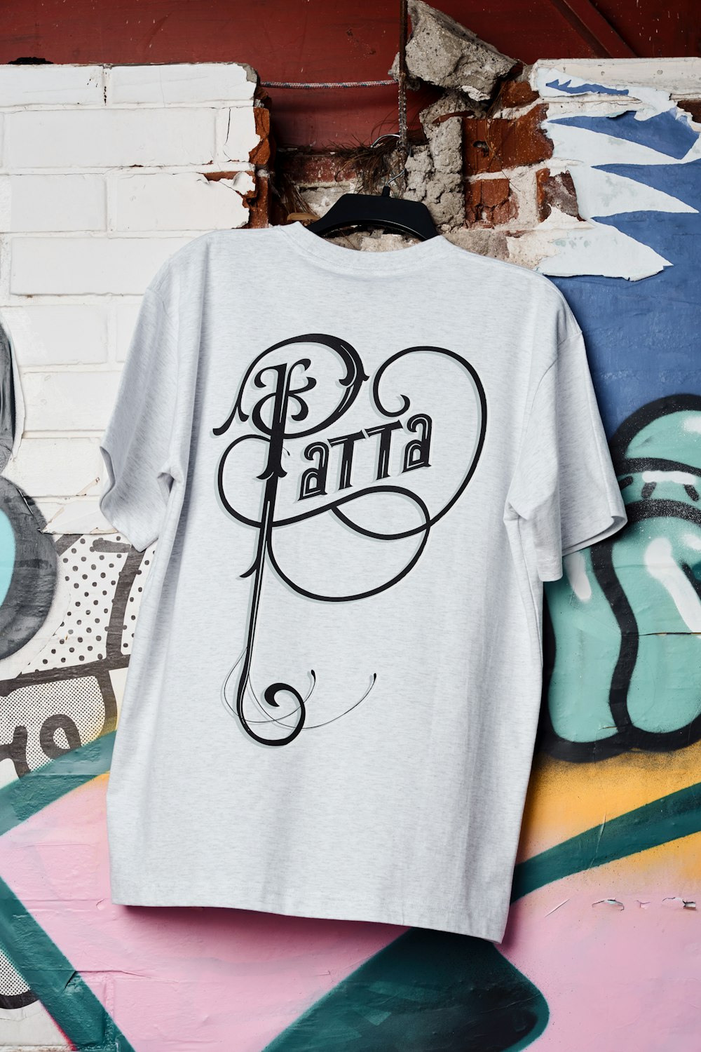 a t - shirt hanging on a wall with graffiti
