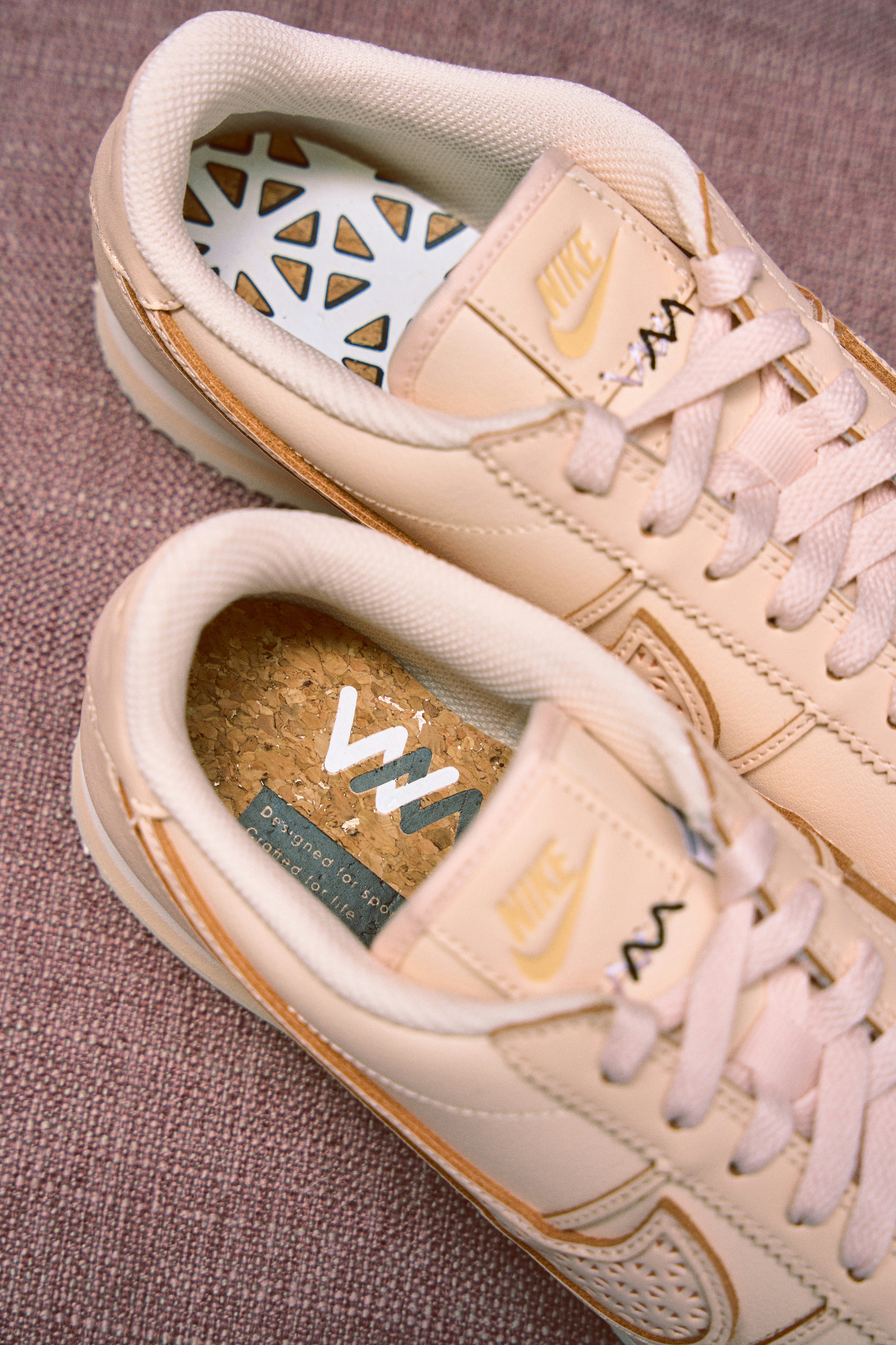 a pair of white and gold nike sneakers