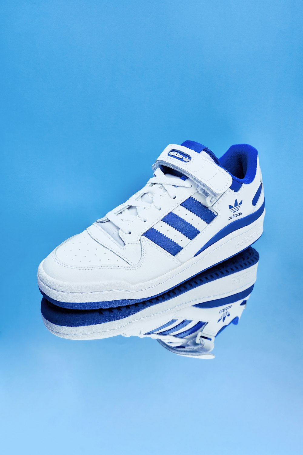 a pair of white and blue shoes on a blue background