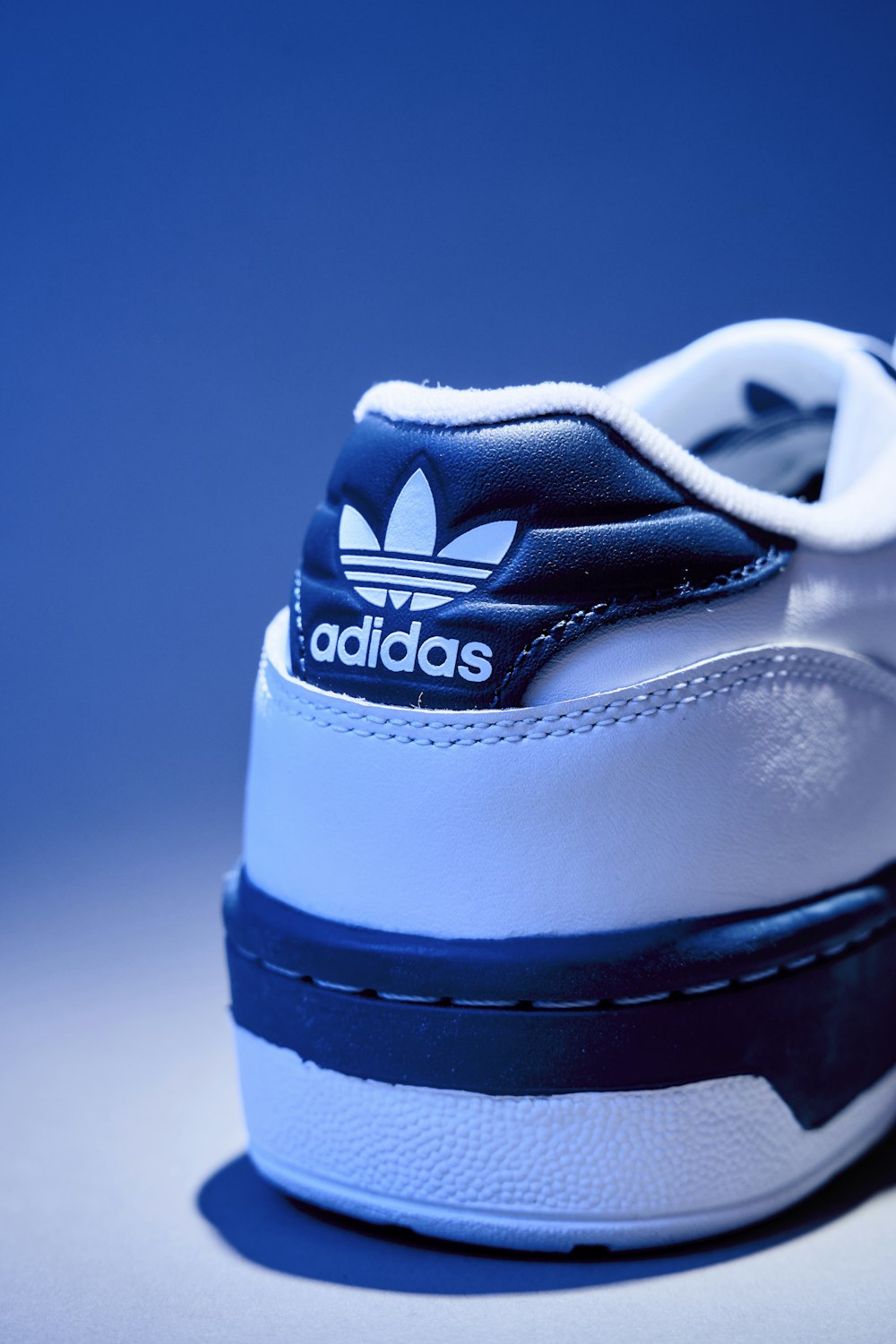 Una sneaker Adidas bianca e blu su un tavolo