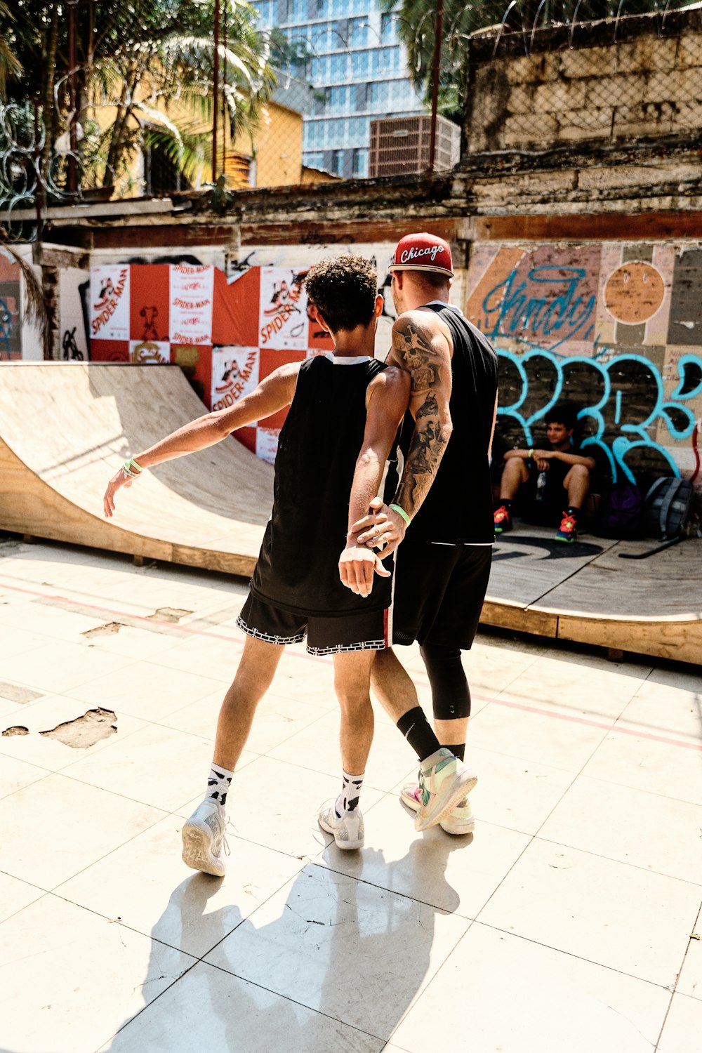 a couple of men standing next to each other on a skateboard