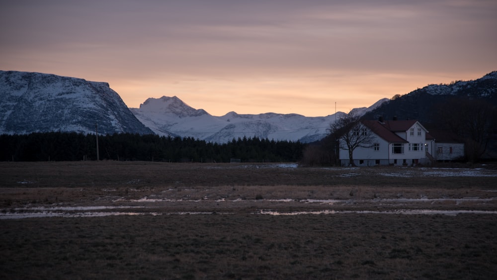 a house in a field with mountains in the background