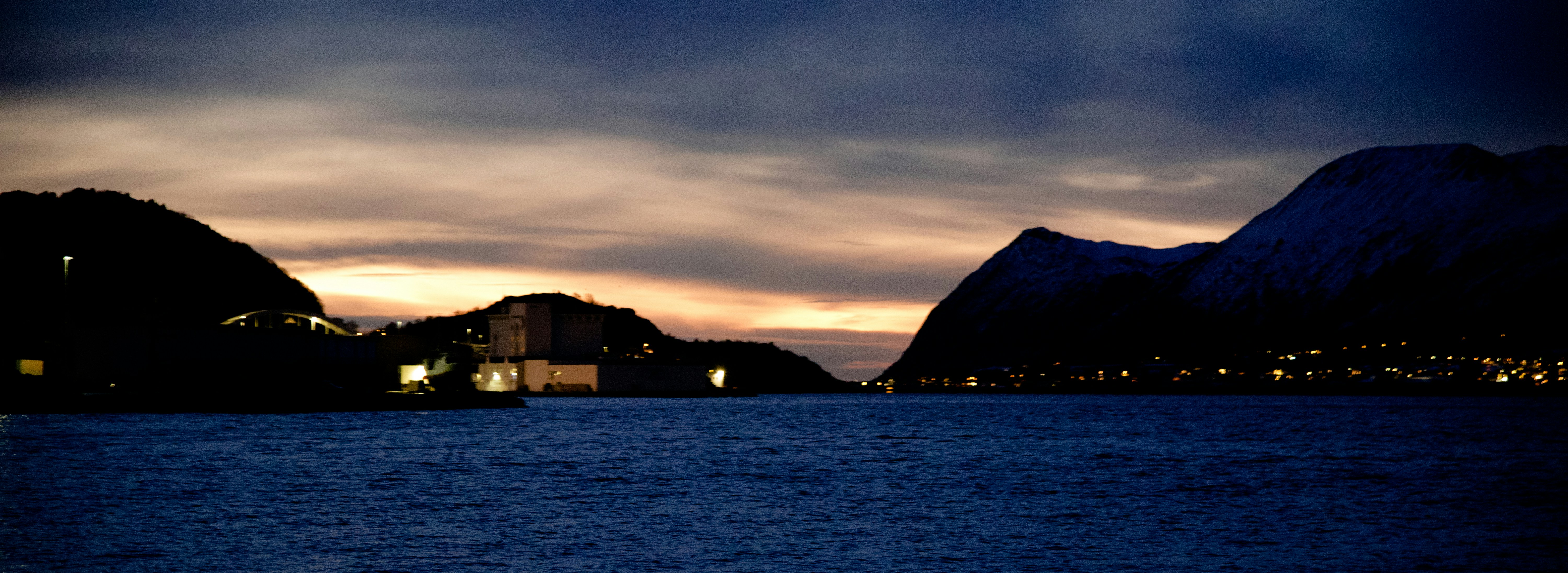 a body of water with mountains in the background