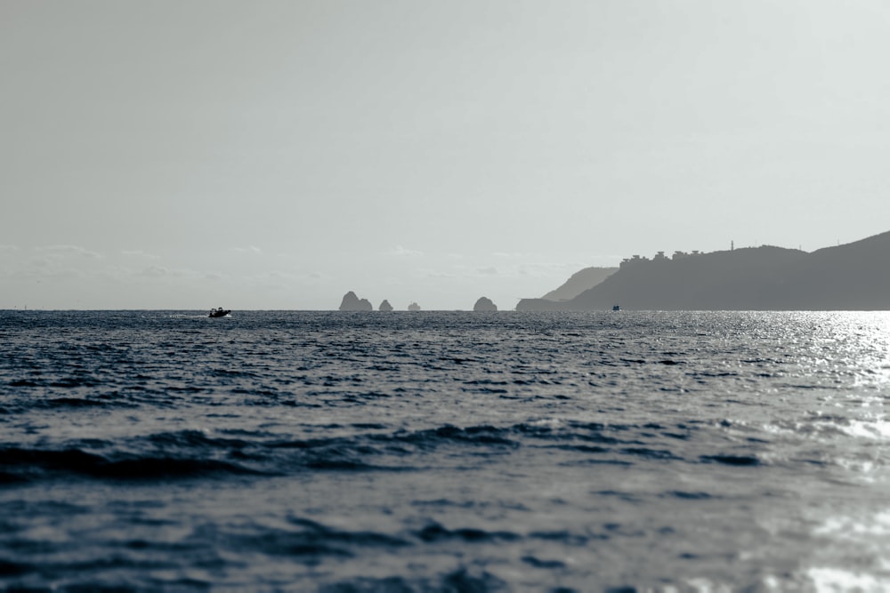 a boat is out on the water near a mountain