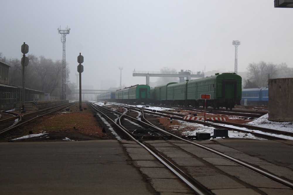 a train traveling down train tracks next to a train station