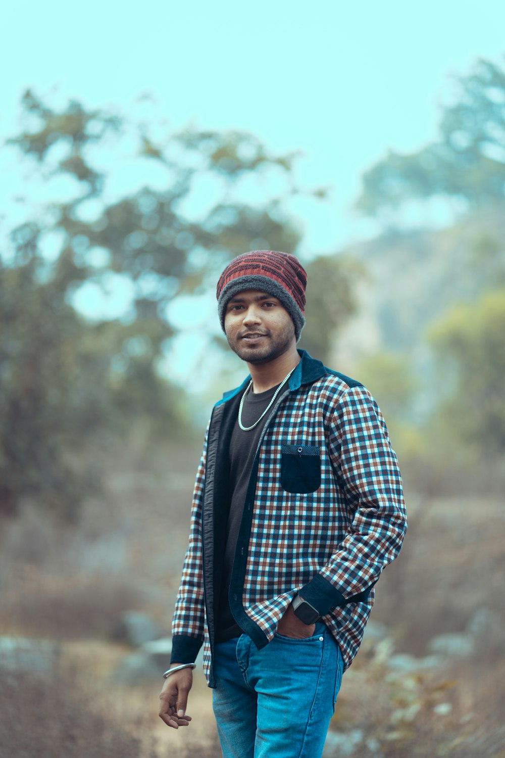 a man standing in a field with a skateboard