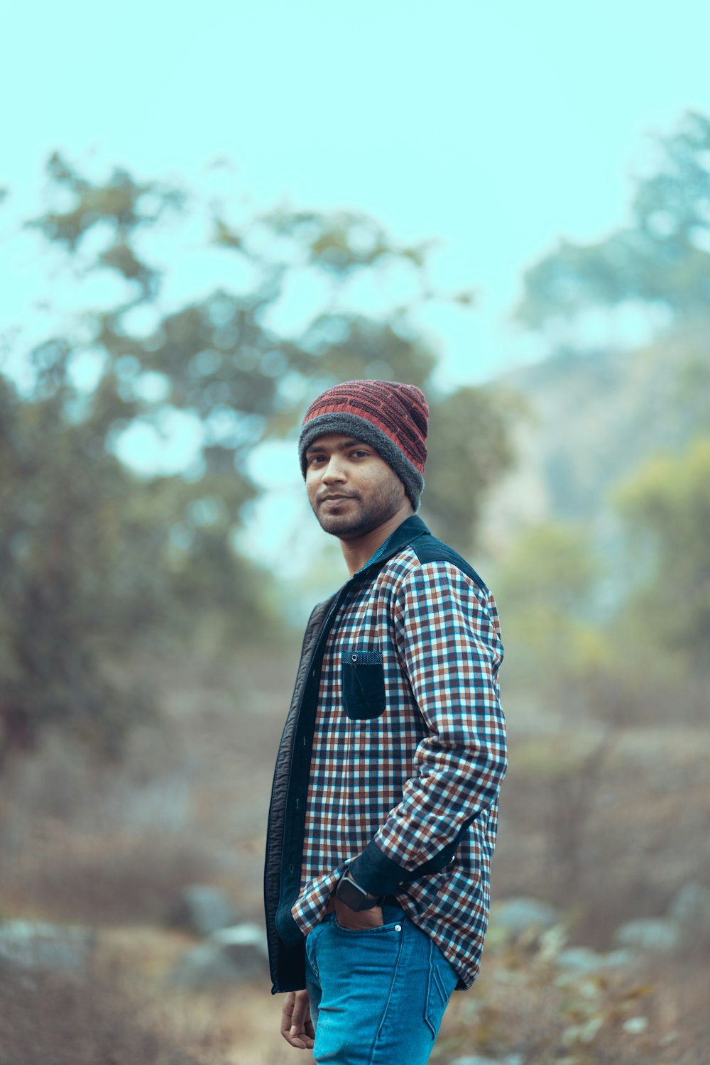 a man standing in a field with a hat on