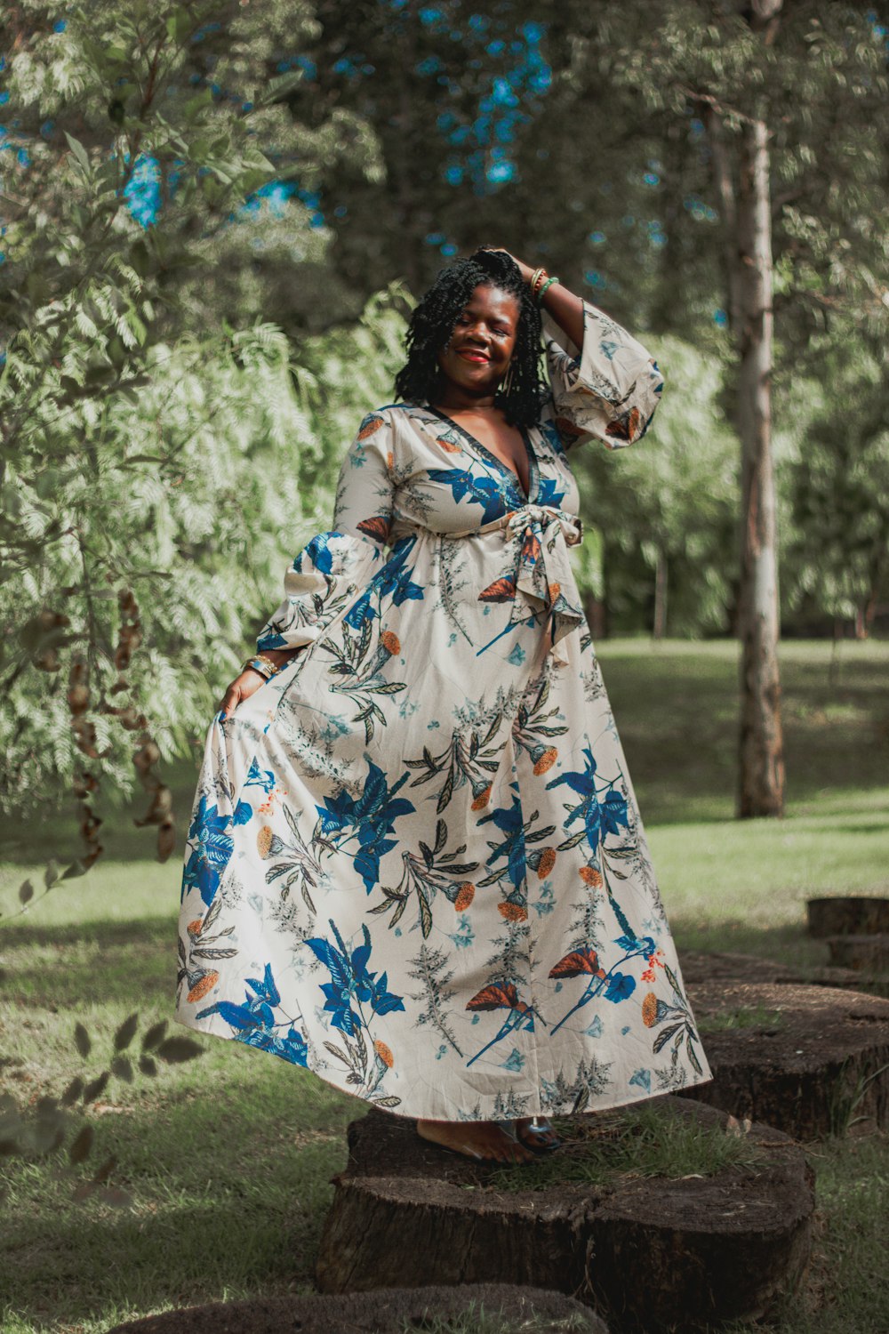 une femme en robe debout dans un parc