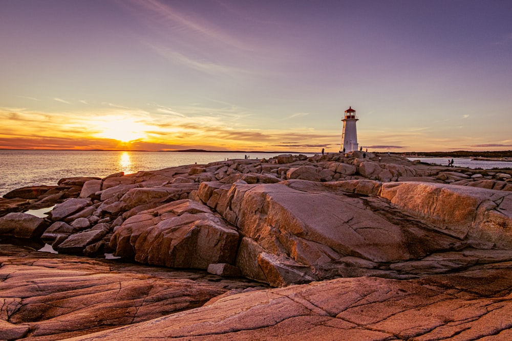 a lighthouse sitting on top of a rocky shore