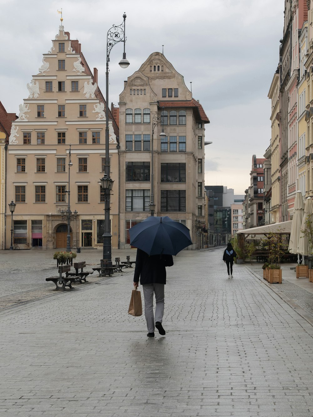 a man walking down a street holding an umbrella