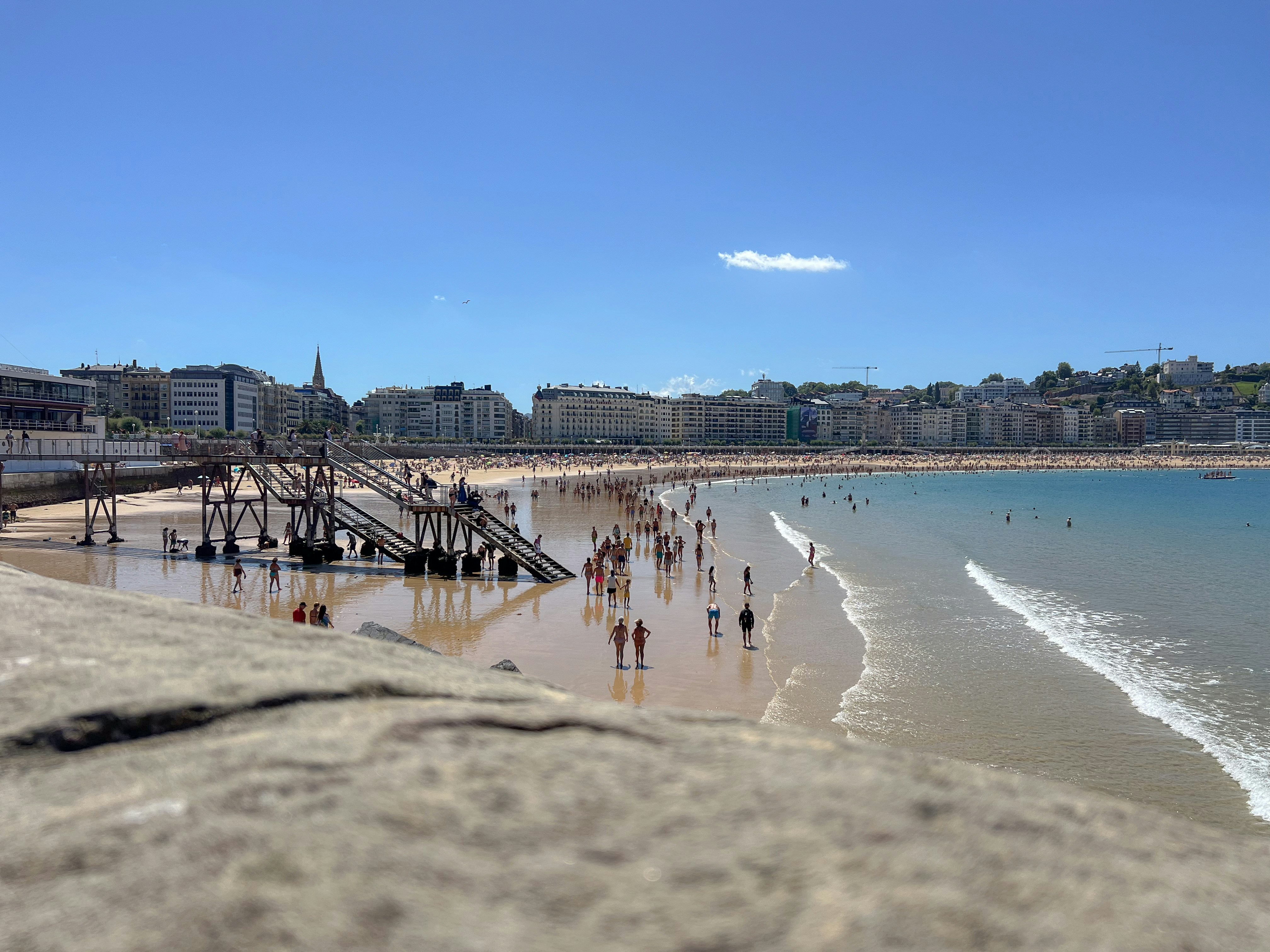 a group of people standing on top of a sandy beach, 