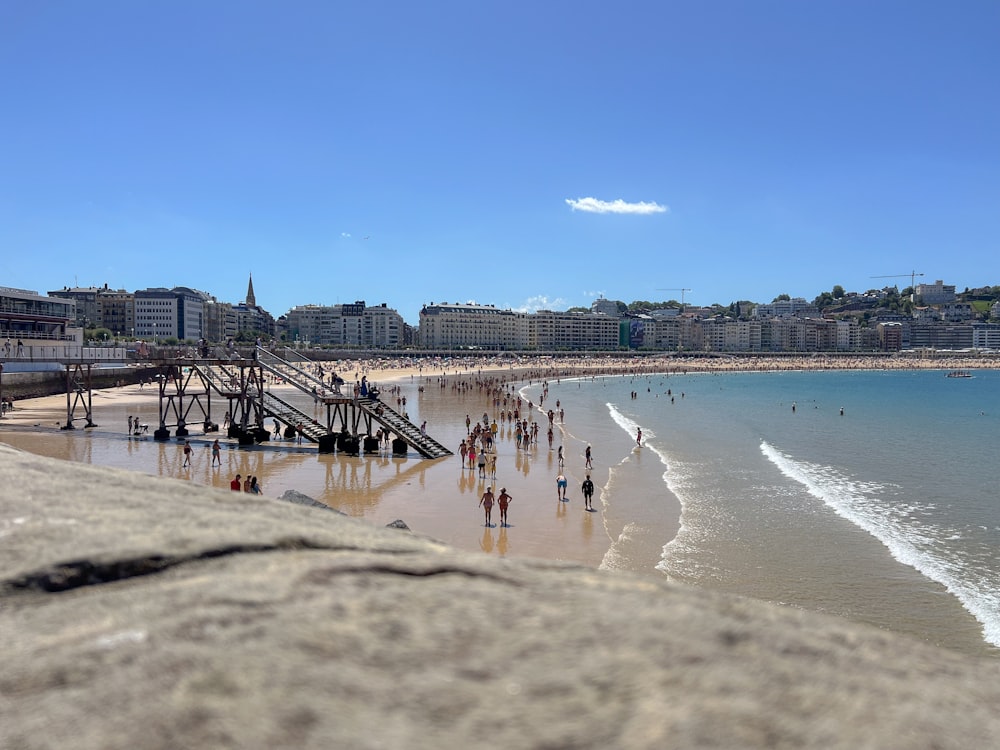 un groupe de personnes debout au sommet d’une plage de sable