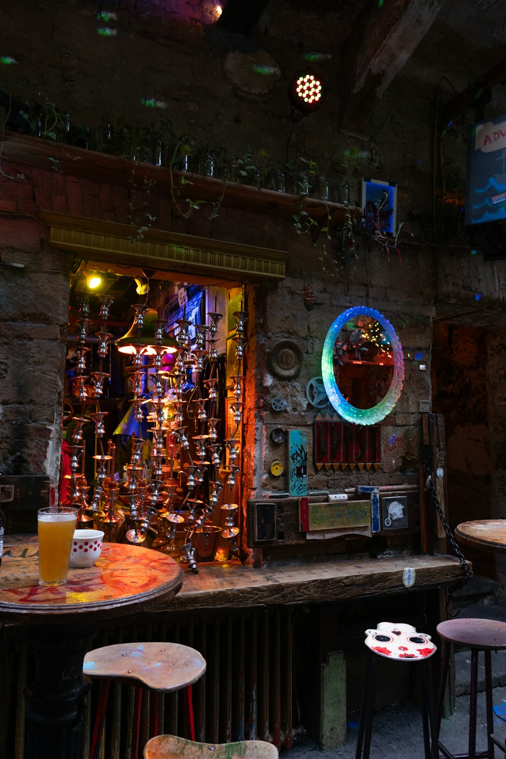 a bar with stools, a table and a mirror