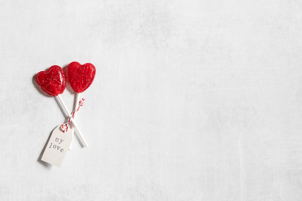 a couple of red hearts sitting on top of a white table