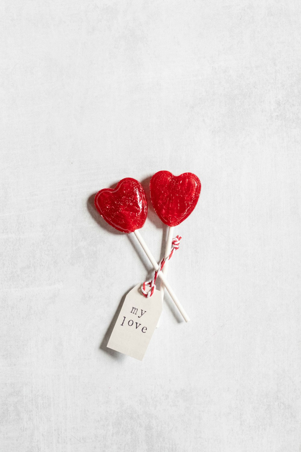two heart shaped lollipops on a stick with a price tag
