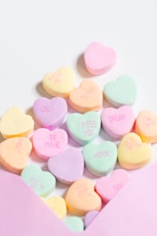 a pink envelope filled with conversation hearts