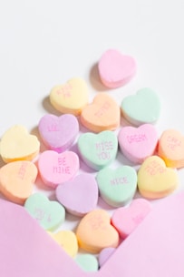 a pink envelope filled with conversation hearts