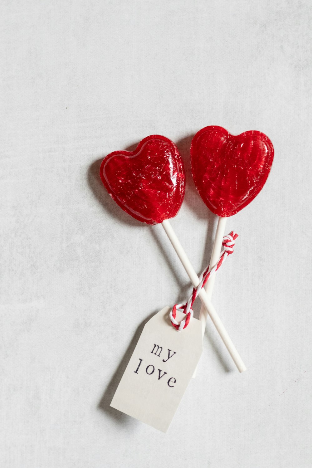 two heart shaped lollipops on a stick with a price tag