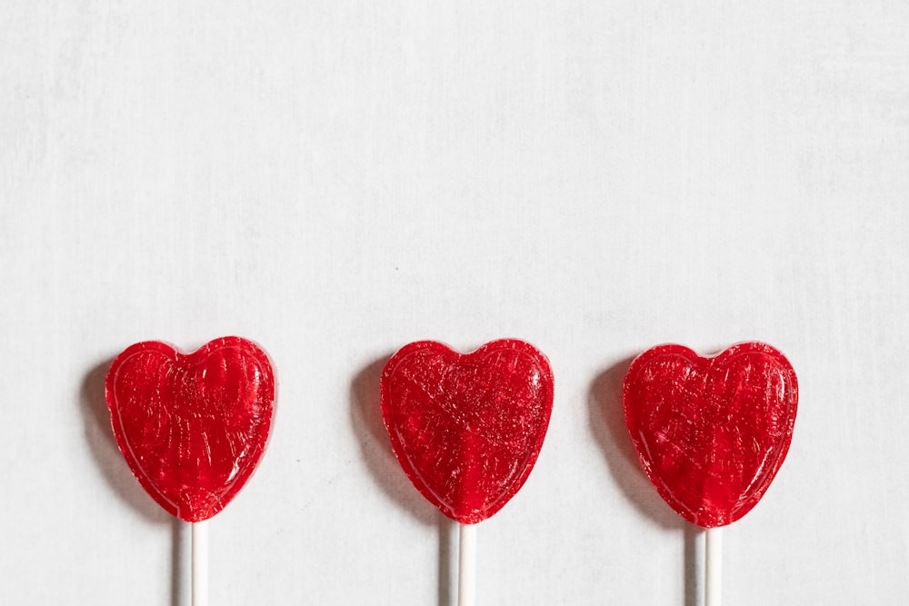 Tres piruletas con forma de corazón en un palo