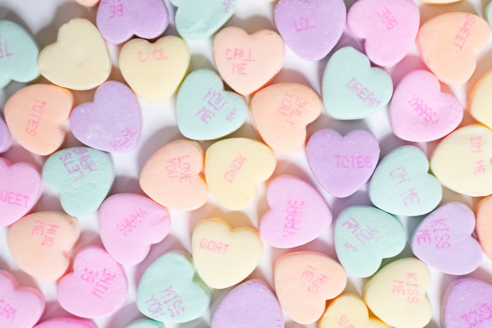 a pile of conversation hearts on a white surface