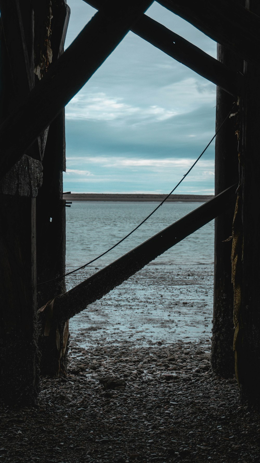 a view of a body of water through a wooden structure