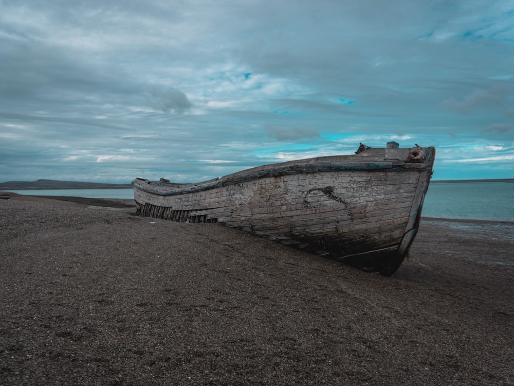 a boat sitting on top of a sandy beach