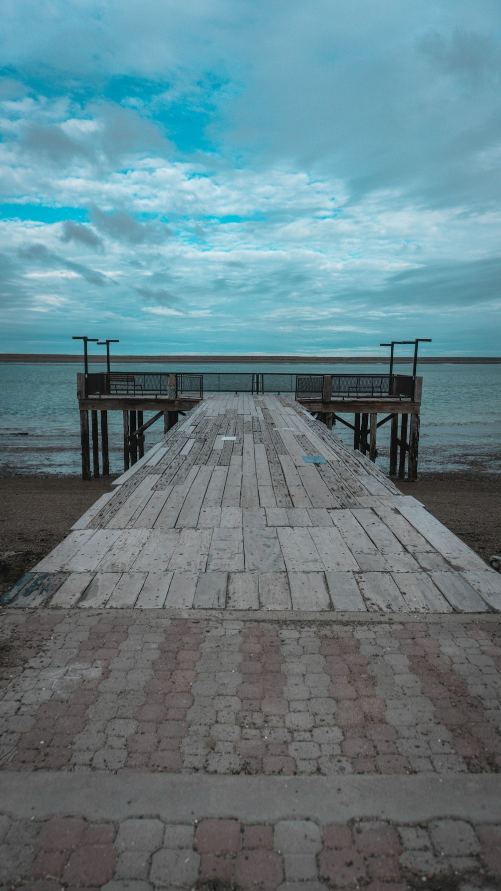 a wooden pier sitting on top of a sandy beach