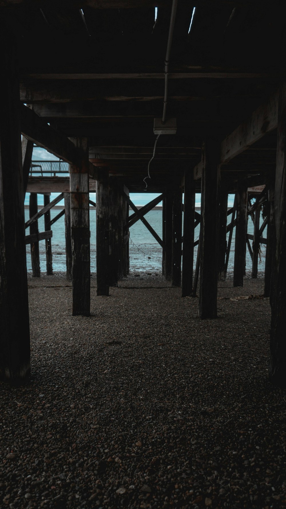 a view of the ocean from underneath a pier