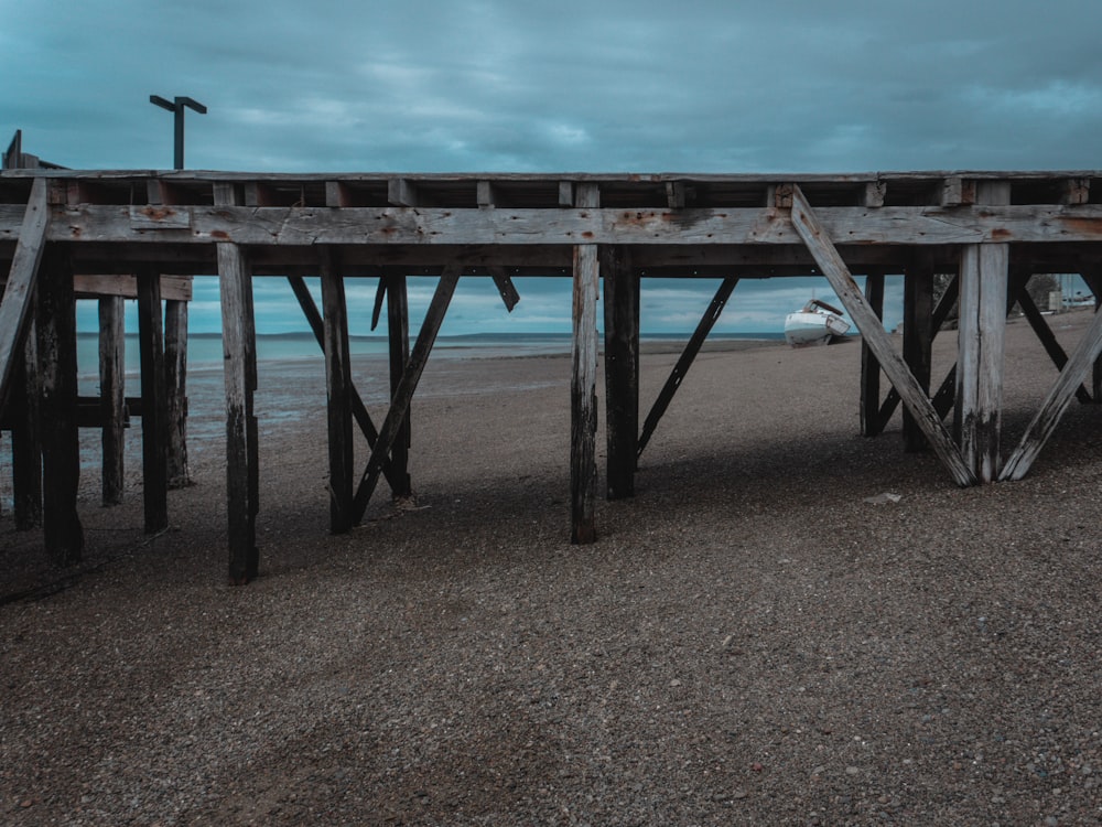 a wooden pier sitting on top of a sandy beach