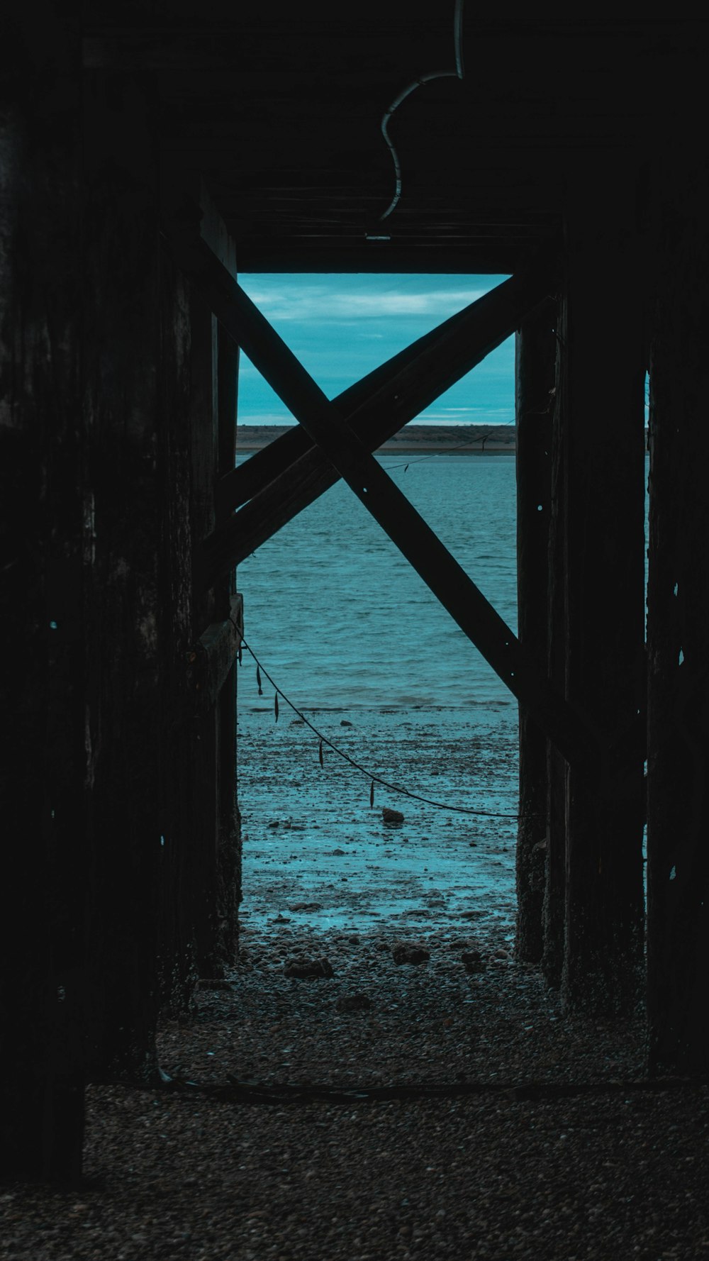 a view of a body of water through a wooden structure