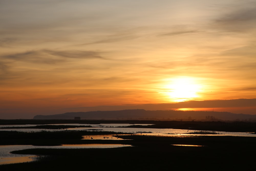 the sun is setting over a body of water