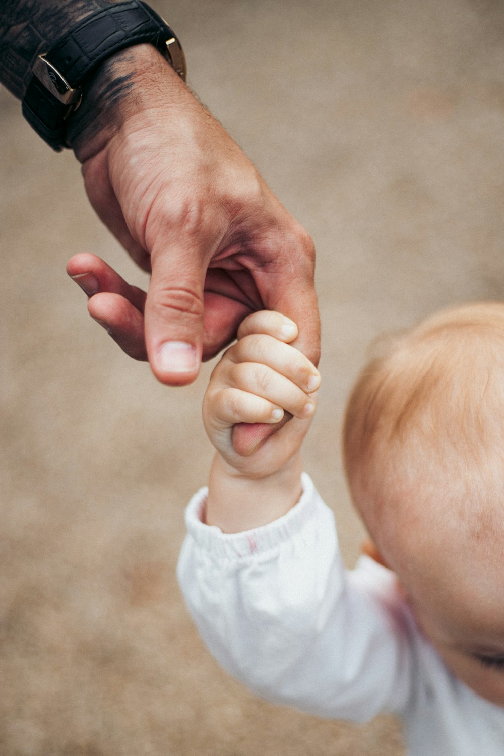 a man holding the hand of a baby