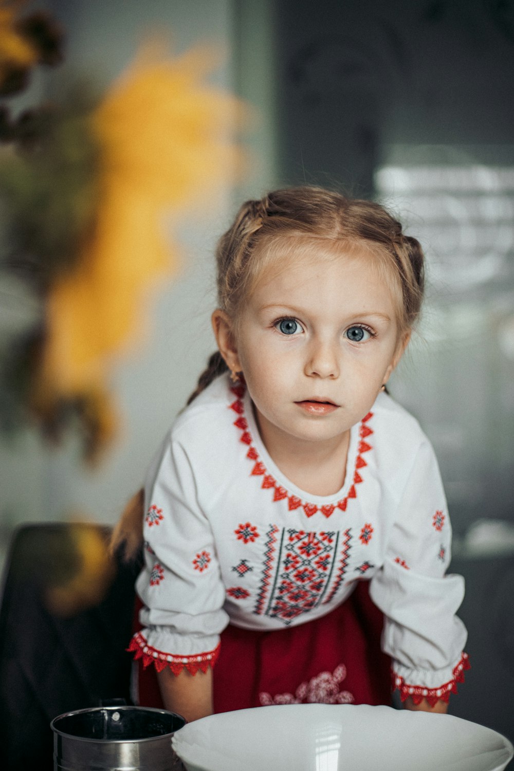 a little girl sitting at a table with a plate