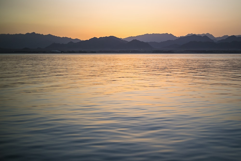 a large body of water with mountains in the background