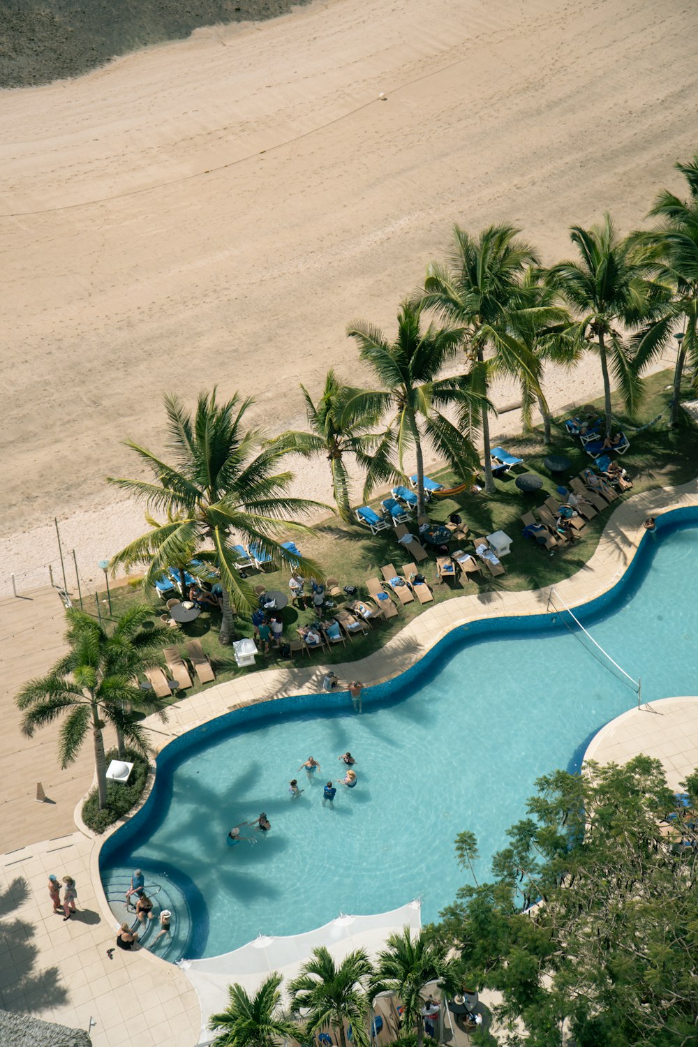 an aerial view of a resort pool and beach