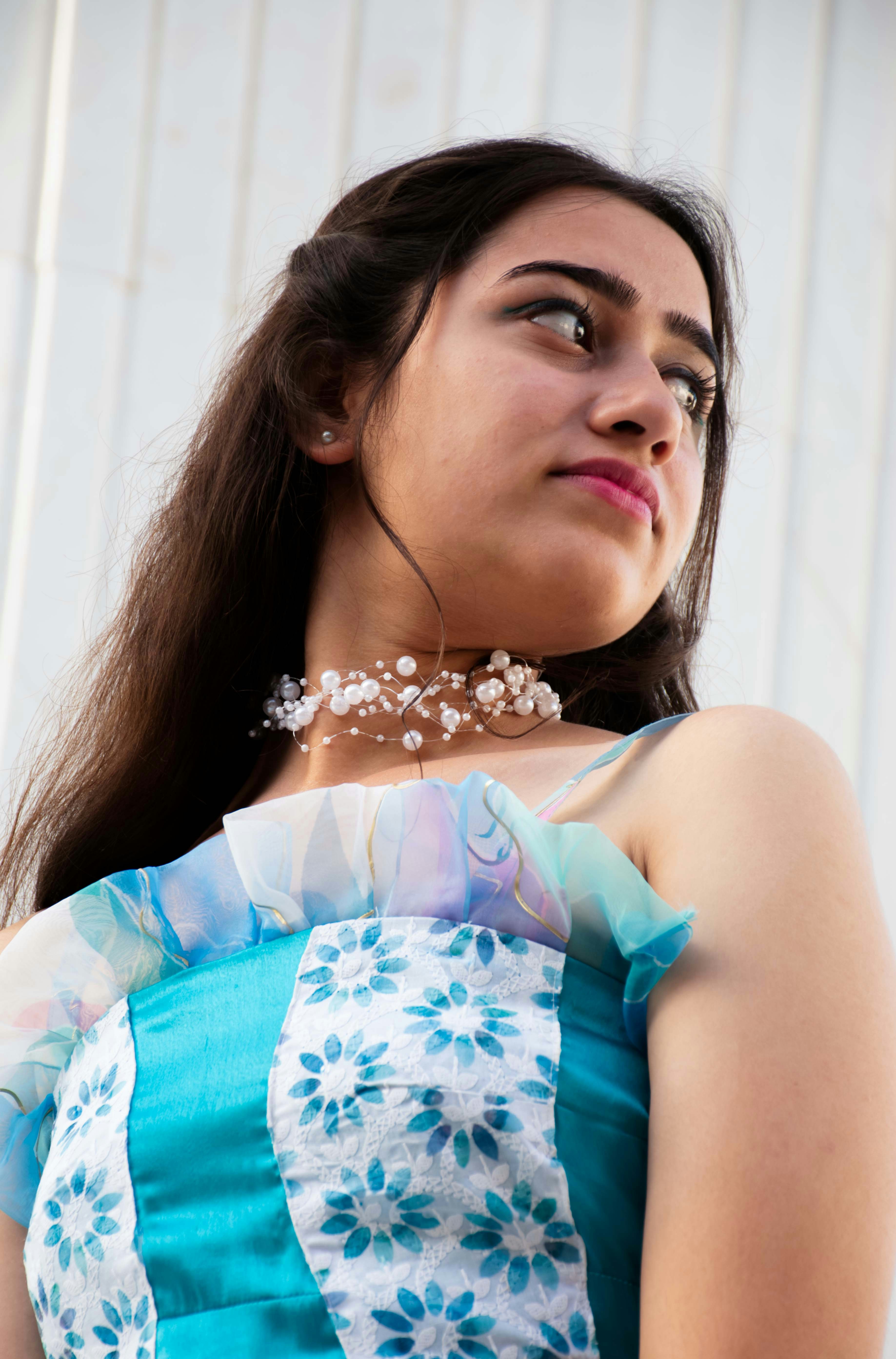 A woman wearing a blue and white dress and a necklace photo – Free ...