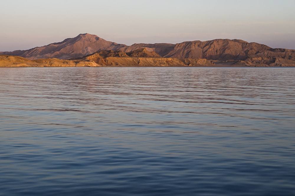 a large body of water with mountains in the background