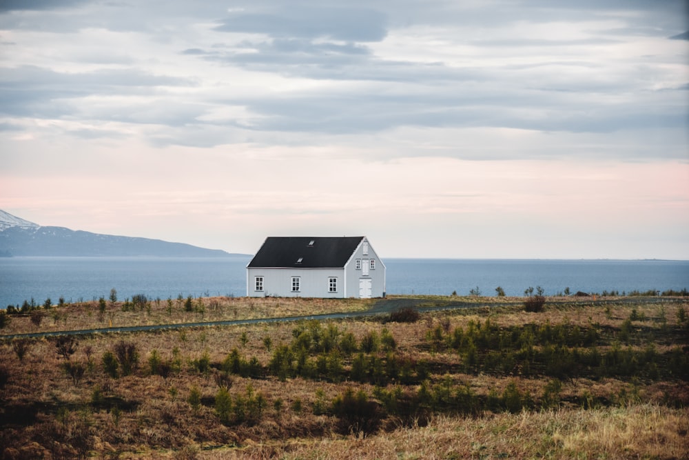 a house on a hill with a body of water in the background