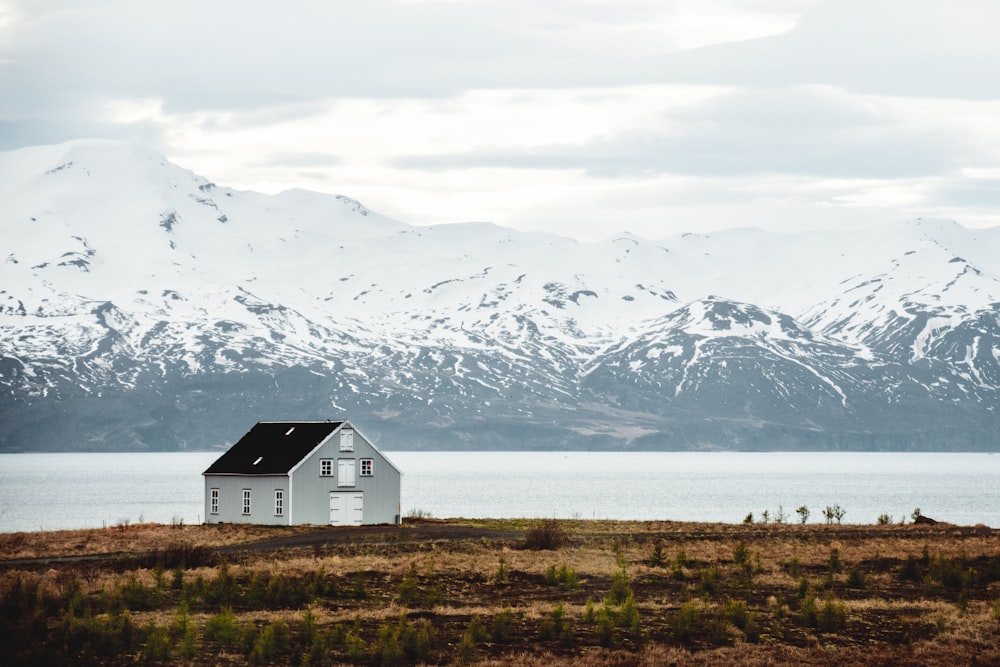 a white house sitting on top of a grass covered field