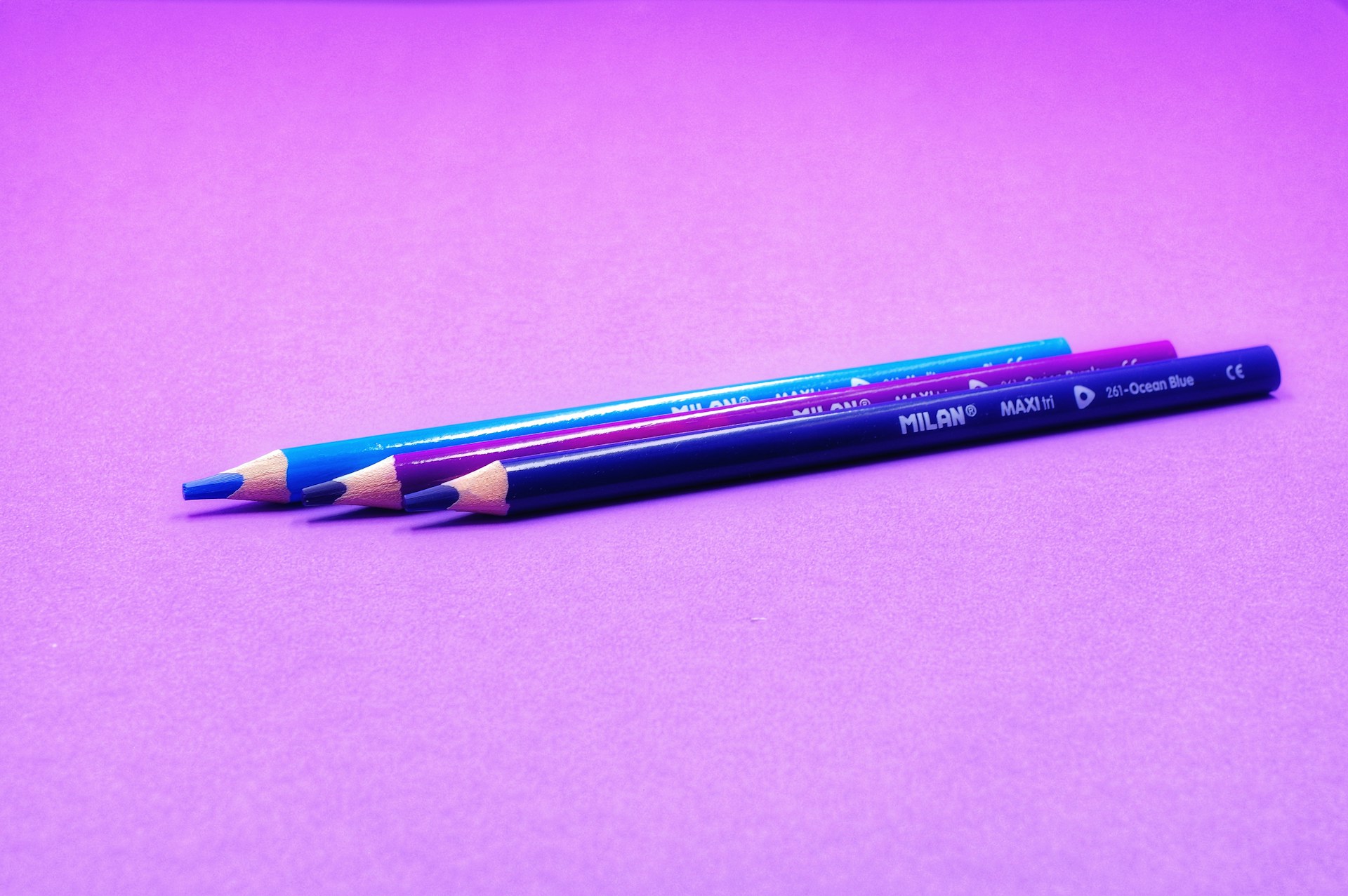 two pencils sitting on top of a purple surface