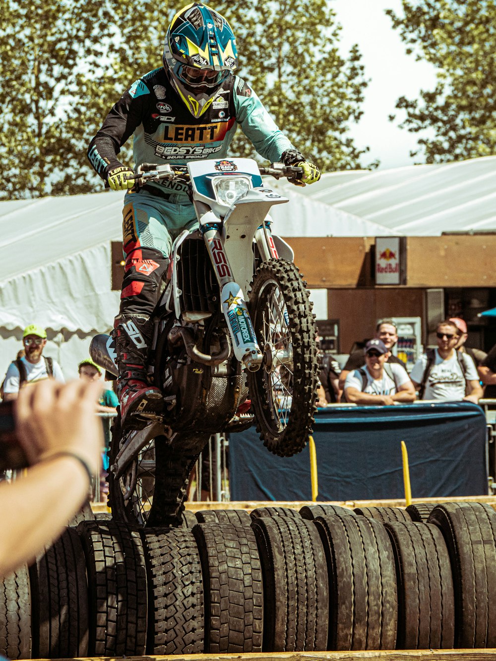 a man riding a dirt bike on top of a pile of tires